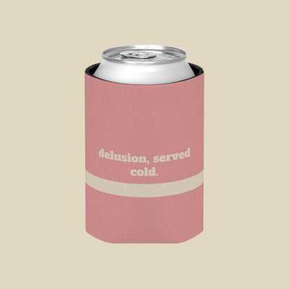 A pink can cooler sleeve with a silver aluminum can inside, featuring the text 'delusion, served cold.' in beige on the front, set against a plain white background.