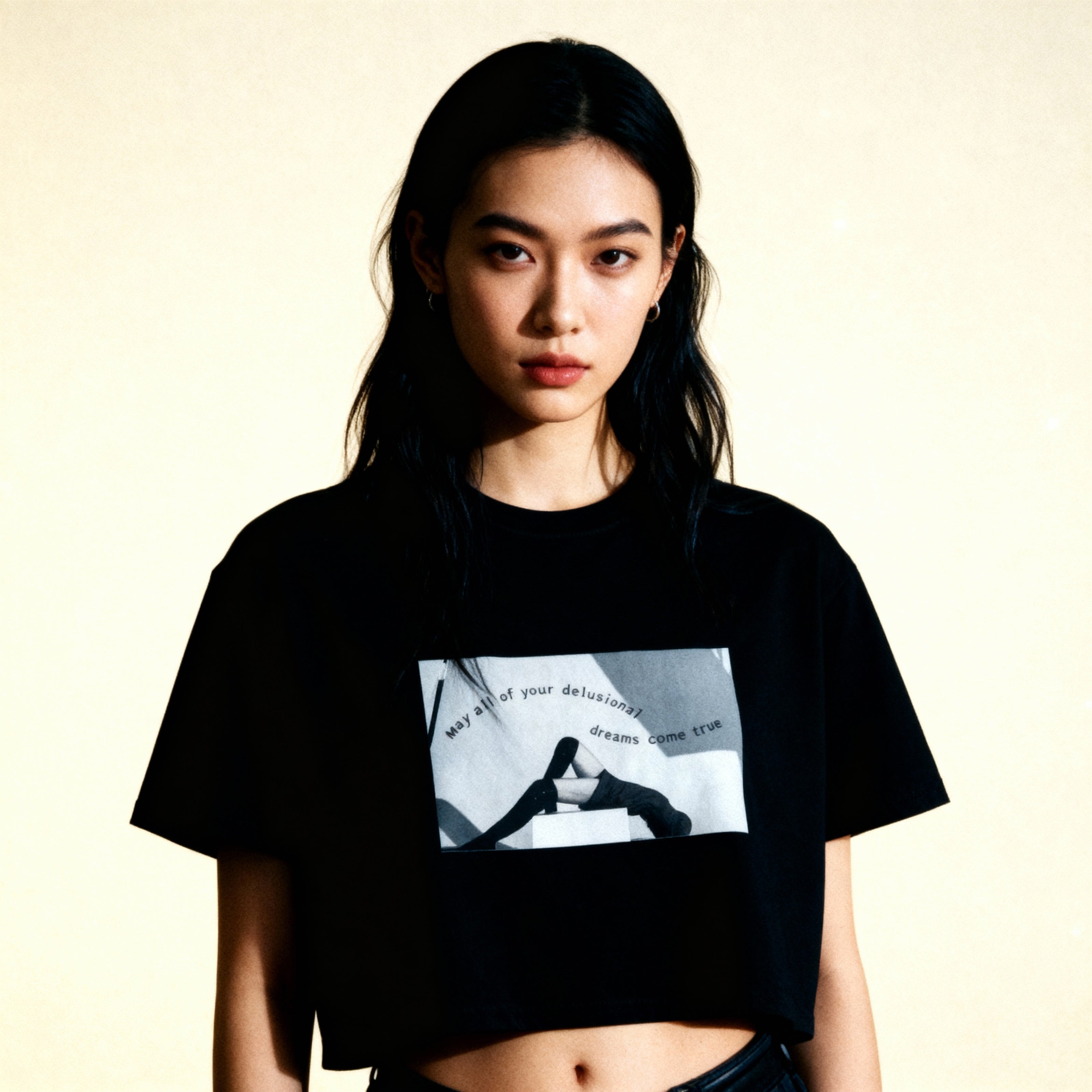 Woman wearing a black t-shirt with a graphic design on a beige background